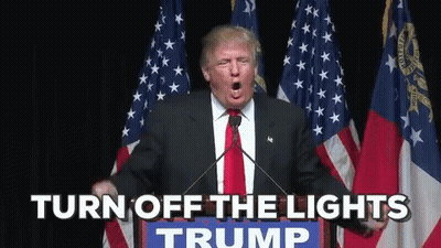 Donald Trump Is Giving A Speech In Front Of American Flags And Says " Turn Off The Lights " GIF