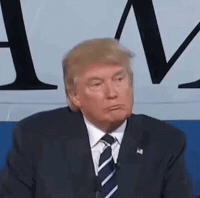 Donald Trump Is Wearing A Suit And Tie And Making A Funny Face While Sitting In Front Of A Microphone . GIF