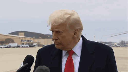 Donald Trump Speaking Into A Microphone In Front Of A Building That Says ' Apollo ' On It GIF
