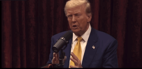 Donald Trump Speaking Into A Microphone With The Words He Goes He 'S A Stupid Son Of A Bitch Written In Yellow GIF