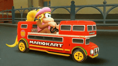 Donkey Kong Is Driving A Red Double Decker Bus With Mariokart On The Side GIF