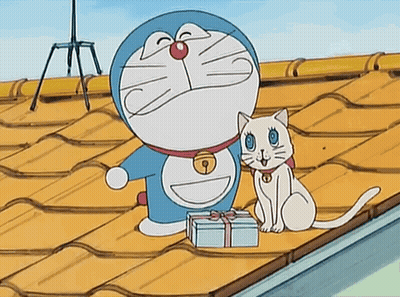 Doraemon And A White Cat Are On A Roof With A Gift Box GIF