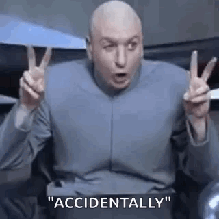 Dr. Evil Is Making A Peace Sign With His Hands While Sitting In A Chair . GIF