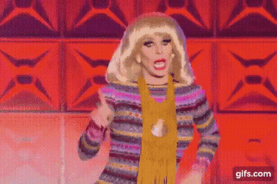 Drag Queen Dancing In Colorful Sweater And Scarf On Stage GIF