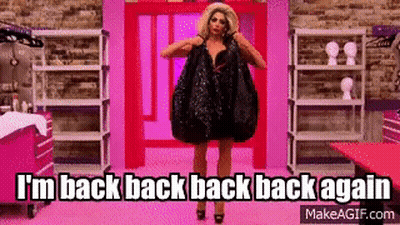 Drag Queen In Black Dress Holding Bag Against Pink Wall GIF