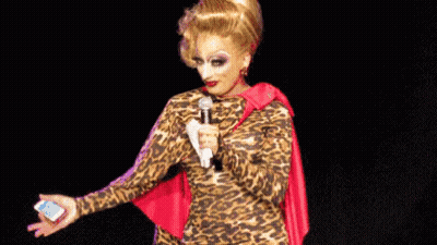 Drag Queen In Leopard Print Dress Holding Microphone GIF