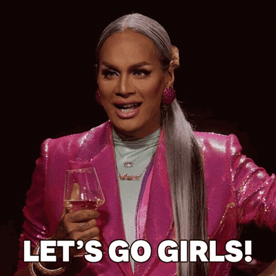 Drag Queen In Pink Jacket Holding Wine Saying Let's Go Girls GIF