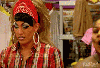 Drag Queen In Plaid Shirt And Red Bandana In Closet GIF
