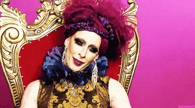 Drag Queen In Purple And Gold Dress With Earrings GIF