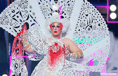 Drag Queen In White And Pink Costume With Heart GIF