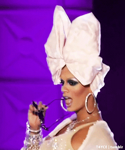 Drag Queen In White Turban And Hoop Earrings Licking Lips GIF