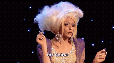Drag Queen In Wig And Earrings Saying Yas Gawd GIF