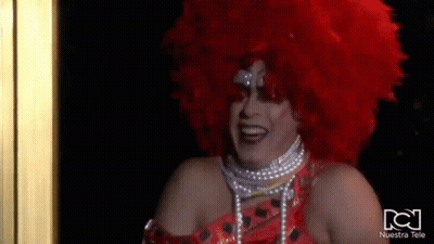 Drag Queen With Red Wig And Pearls Smiling GIF
