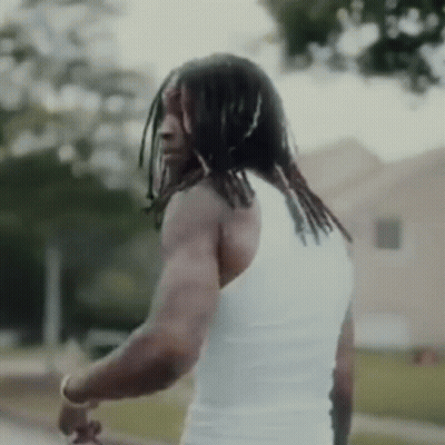 Dreadlocked Man In White Tank Top By Building GIF