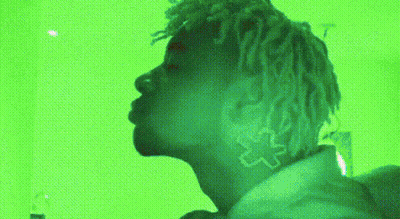 Dreadlocked Person By Green Wall GIF