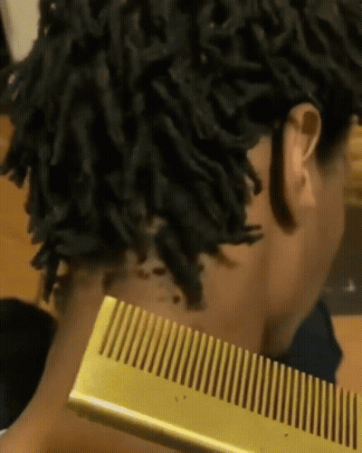 Dreadlocked Woman Holding Gold Comb To Neck GIF