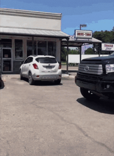 Drive-Thru Tobacco Shop With White SUV GIF