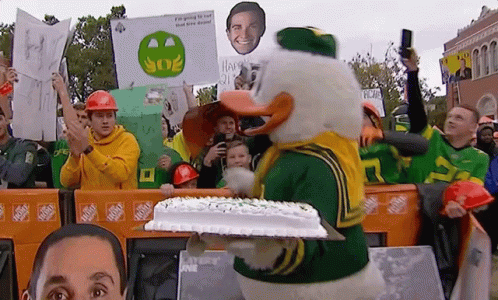 Duck Mascot Holding Cake GIF