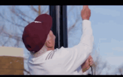 Elderly Man In Maroon Hat Hanging Light Pole GIF