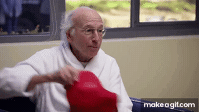 Elderly Man In Robe Holding Red Hat GIF