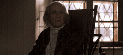 Elderly Man In Rocking Chair By Stained Glass Window GIF