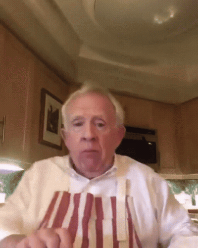 Elderly Man In Striped Apron And White Shirt Looking At Camera GIF