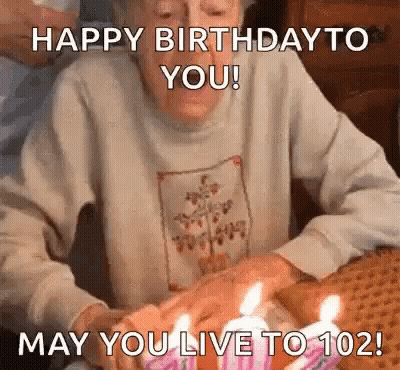 Elderly Woman Blowing Out Birthday Cake Candles GIF