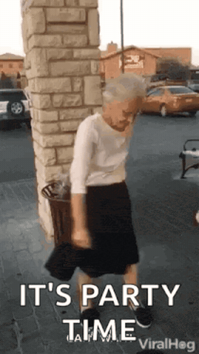 Elderly Woman Dancing In Brick Building Parking Lot GIF