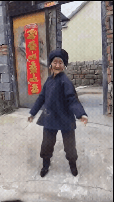 Elderly Woman Dancing In Front Of Door With Chinese Characters GIF