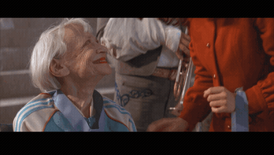 Elderly Woman In Blue And White Adidas Jacket Smiling GIF