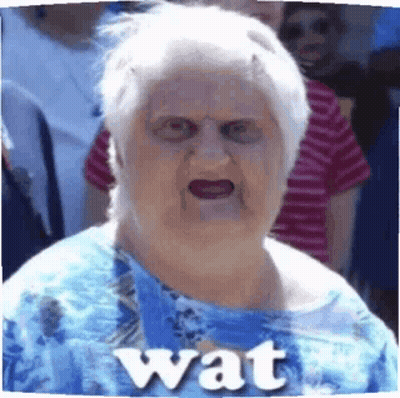 Elderly Woman in Blue Shirt Making Funny Face Saying Wat