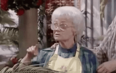 Elderly Woman In Glasses And Apron Sitting GIF
