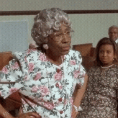 Elderly Woman In Glasses And Floral Shirt In Church GIF