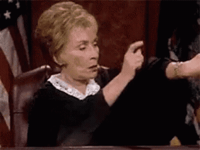 Elderly Woman Sitting At Courtroom Table GIF