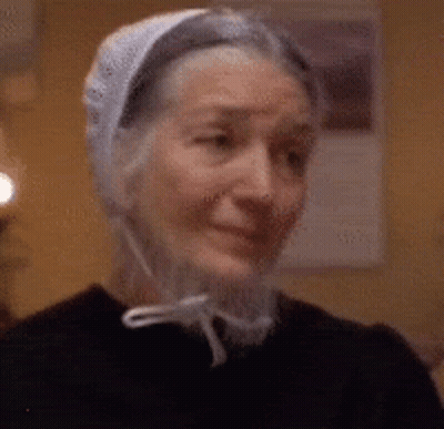 Elderly Woman Smiling in White Hat and Black Shirt
