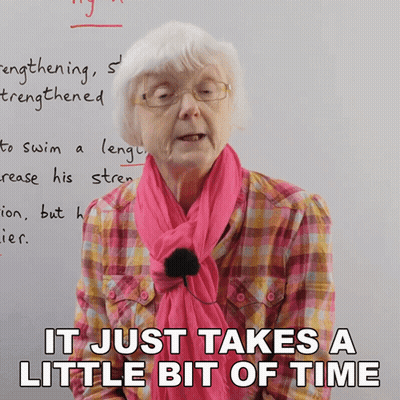 Elderly Woman With Glasses And Pink Scarf Saying It Just Takes A Little Bit Of Time GIF