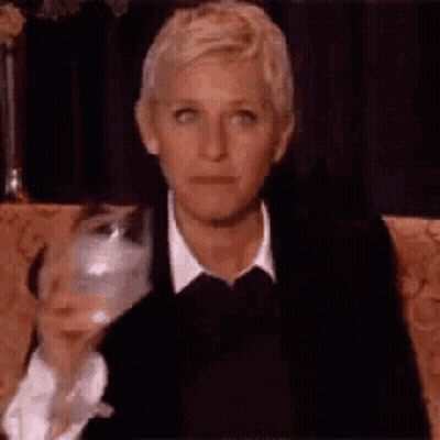 Ellen Degeneres Is Sitting On A Couch With A Glass Of Wine . GIF