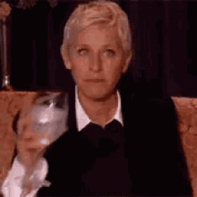 Ellen Degeneres Is Sitting On A Couch With A Glass Of Wine . GIF