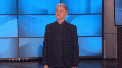 Ellen Degeneres Is Standing In Front Of A Blue Wall On Ellentube GIF