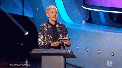 Ellen Degeneres Stands At A Podium Holding A Piece Of Paper That Says Game Of Games On The Bottom GIF