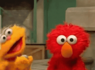 Elmo And Ernie From Sesame Street Are Standing Next To Each Other And Looking At Each Other . GIF