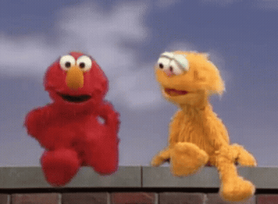 Elmo And Fozzie Are Sitting On A Brick Wall . GIF