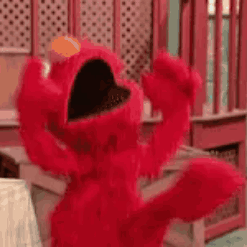 Elmo From Sesame Street Is Dancing In A Room With His Arms Outstretched . GIF