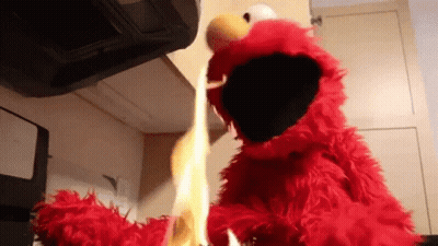 Elmo From Sesame Street Is Holding A Flame In His Hands GIF