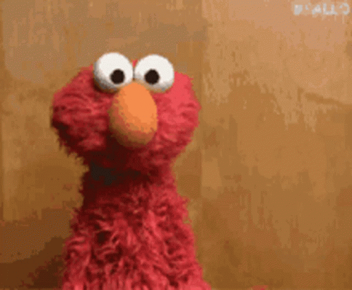 Elmo From Sesame Street Is Holding A Red Heart In His Hands GIF