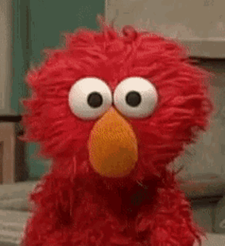 Elmo From Sesame Street Is Making A Funny Face With His Big Eyes . GIF