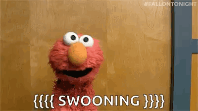 Elmo From Sesame Street Is Sitting In Front Of A Wooden Wall And Saying Swooning . GIF
