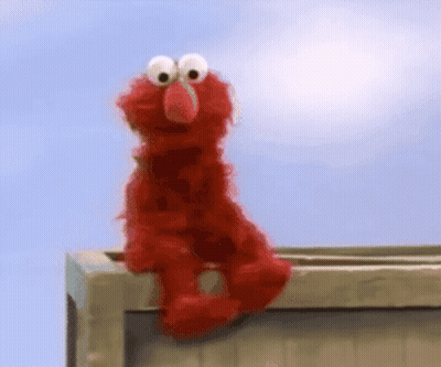 Elmo From Sesame Street Is Sitting On A Wooden Box GIF