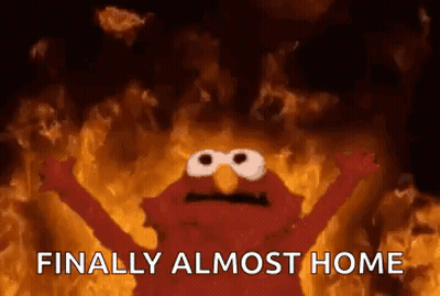 Elmo From Sesame Street Is Standing In Front Of A Fire . GIF