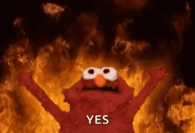Elmo From Sesame Street Is Standing In Front Of A Fire With His Arms In The Air . GIF